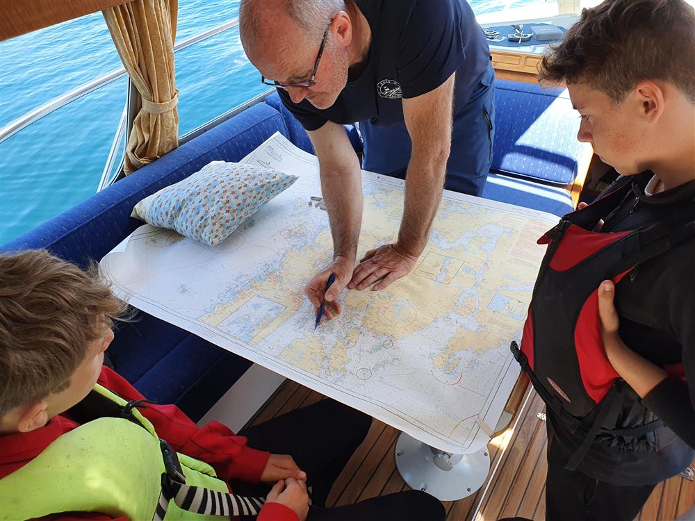 Arild Ognøy visar vegen til Kopervik kor dei sel softis, til Trym Karoliussen og Albert Lindanger, under den praktiske delen av båtførarprøven. - Klikk for stort bilete